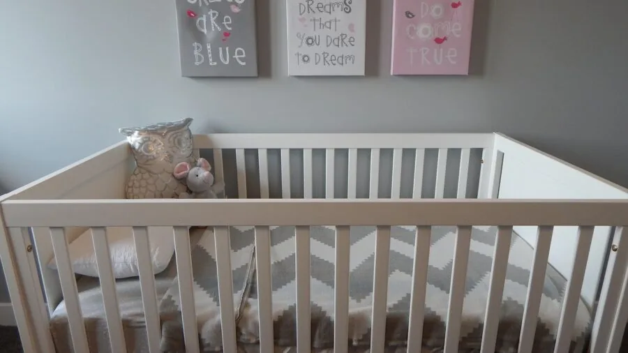 Contemporary nursery with minimalist decor and natural lighting above crib