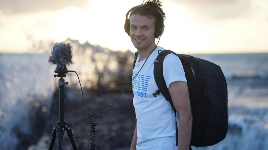 Content creator wearing headphones while recording podcast in home studio setup