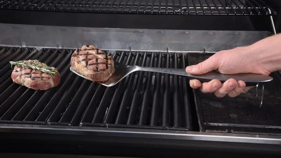 Cook flipping food in skillet with flexible spatula demonstrating blade bend and control