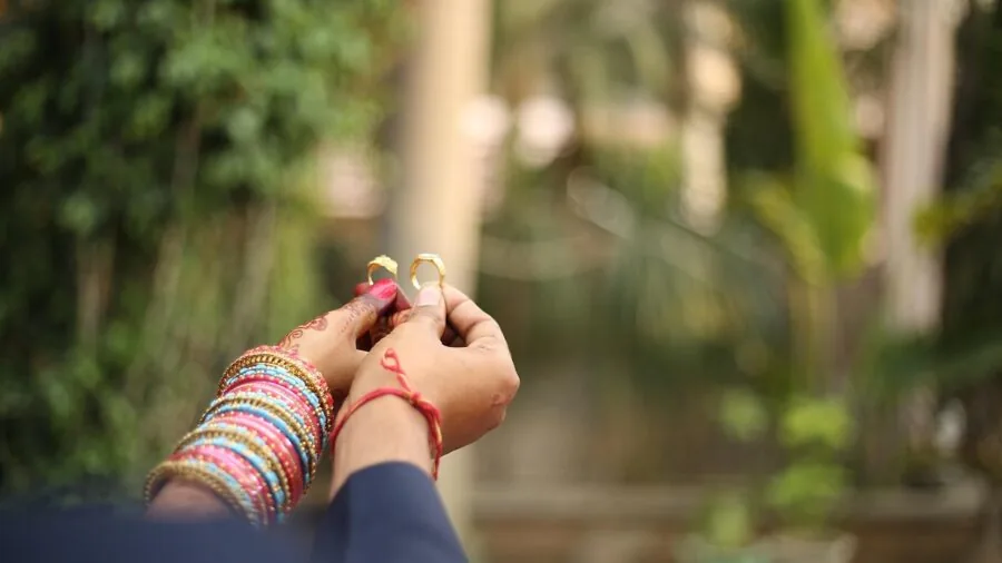 Couple inspecting and discussing gold jewelry pieces together in natural lighting