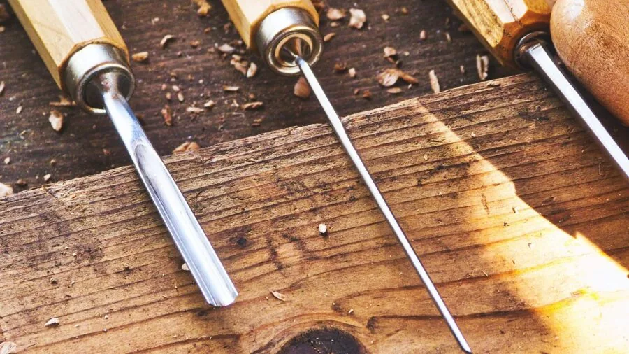 Craftsperson carefully adjusting tension on workshop equipment with focused hands