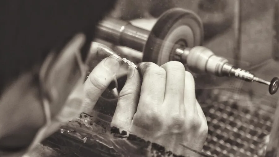 Craftsperson examining and comparing various tool attachments on workbench in home workshop