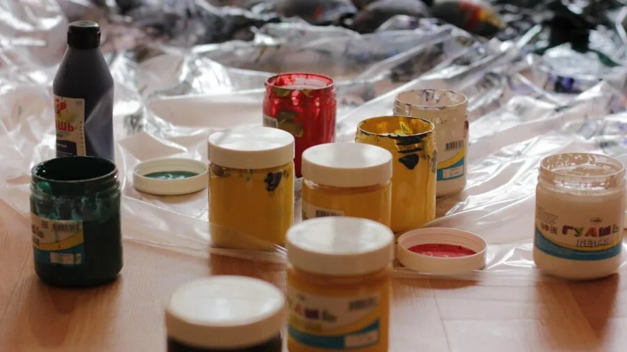Creative person examining and comparing different art materials on workspace table