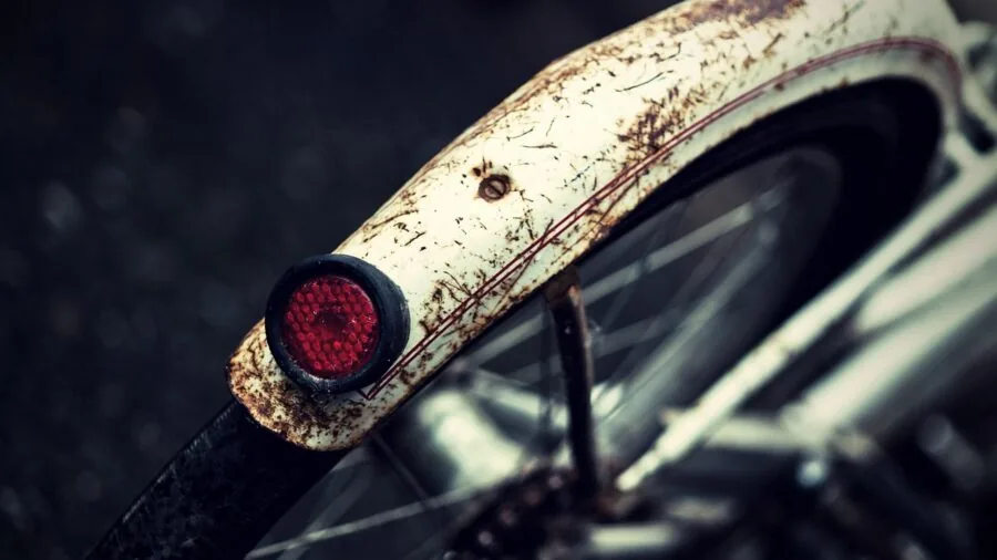 Cyclist adjusting fender on bicycle frame during outdoor maintenance and repair work