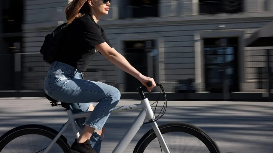 Cyclist adjusting seat height on electric bike to test frame fit and comfort