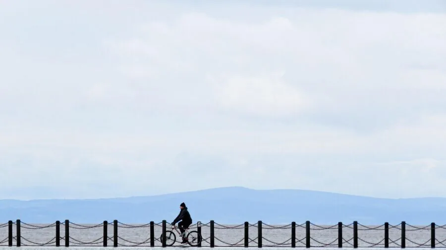 Cyclist in motion on road, perspiring during intense training session on sunny day