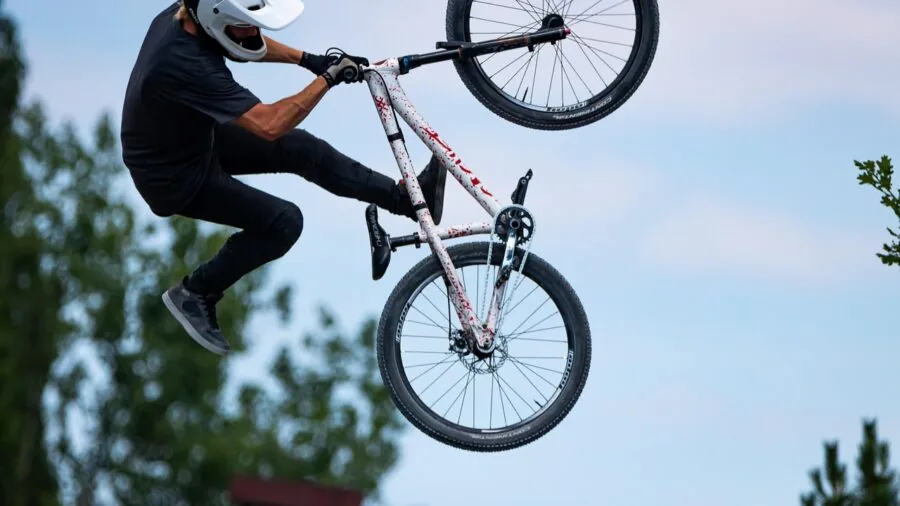 Cyclist in outdoor setting wearing helmet equipped with front-mounted camera for recording rides