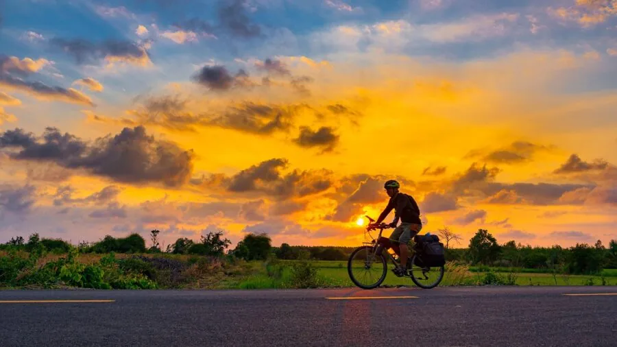 Cyclist in reflective gear riding on road during twilight for visibility and safety