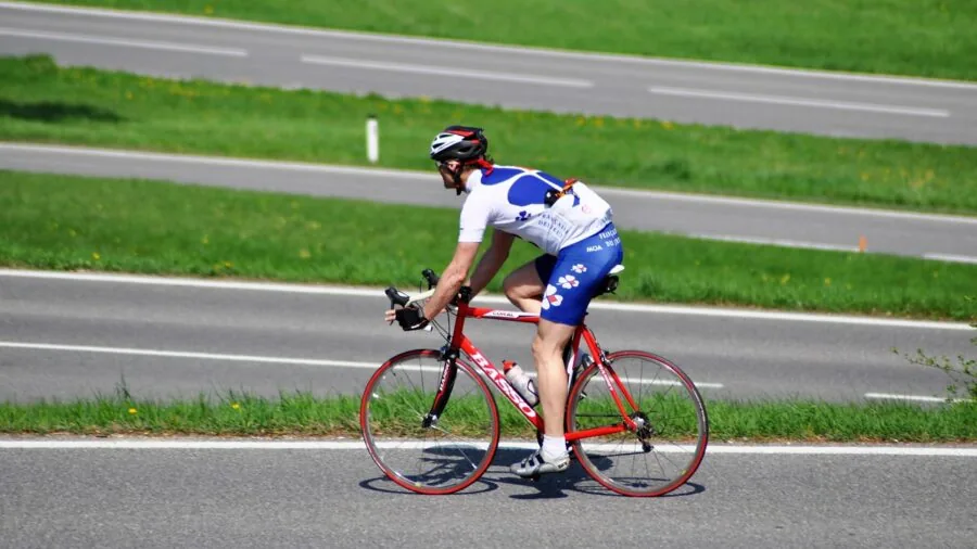 Cyclist inspecting and maintaining bike chain during outdoor ride on sunny trail
