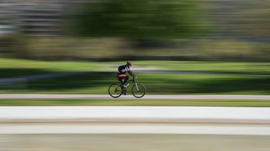 Cyclist inspecting road bike wheel and tire clearance in natural outdoor setting