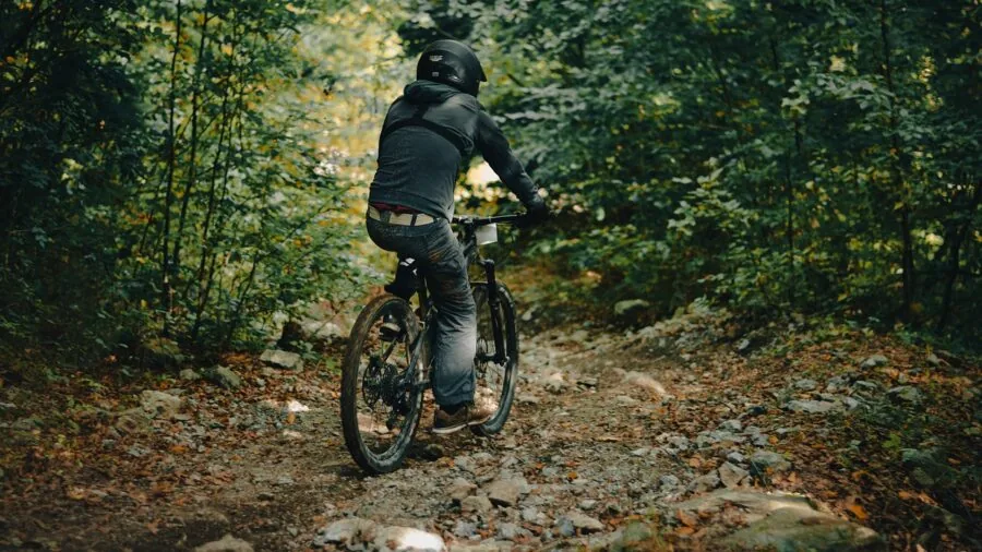 Cyclist riding bike on uneven outdoor trail with natural ground surface