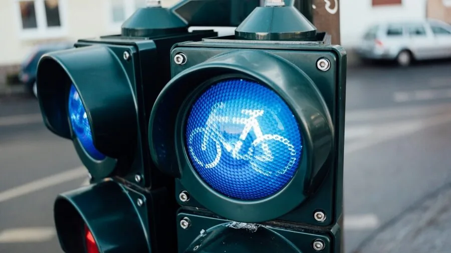 Cyclist riding on urban street during dusk with reflective gear visible for low-light commute safety