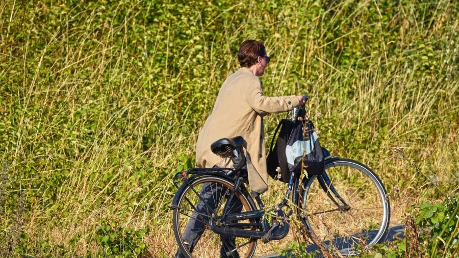 Cyclist riding uphill on mountain trail, demonstrating power and effort during steep climb