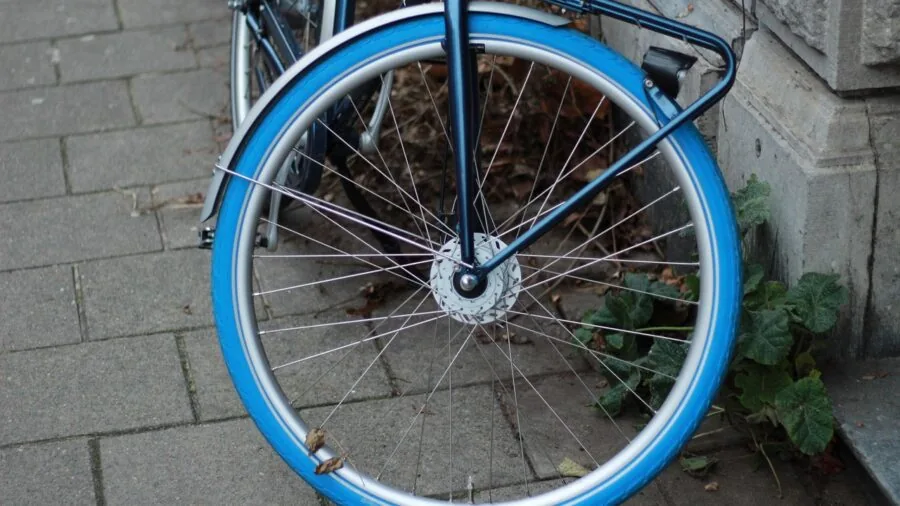 Cyclist using portable pump to inflate bicycle tire during outdoor ride on rural road