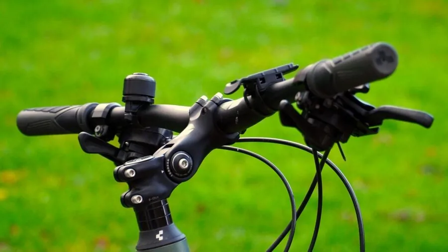 Cyclist viewing smartphone mounted on bike handlebars during outdoor ride
