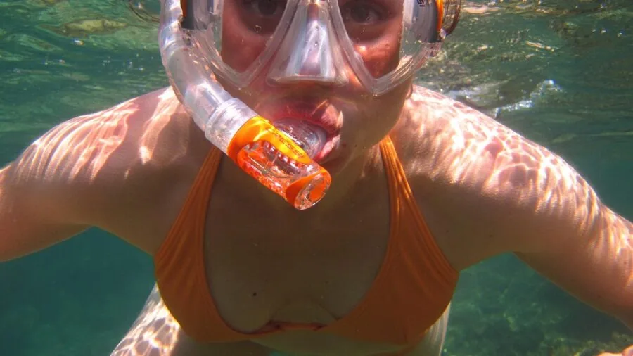 Diver adjusting mask seal before diving underwater in ocean