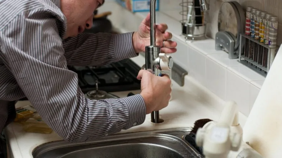 DIY enthusiast carefully applying thread sealant to pipe fitting with precision applicator