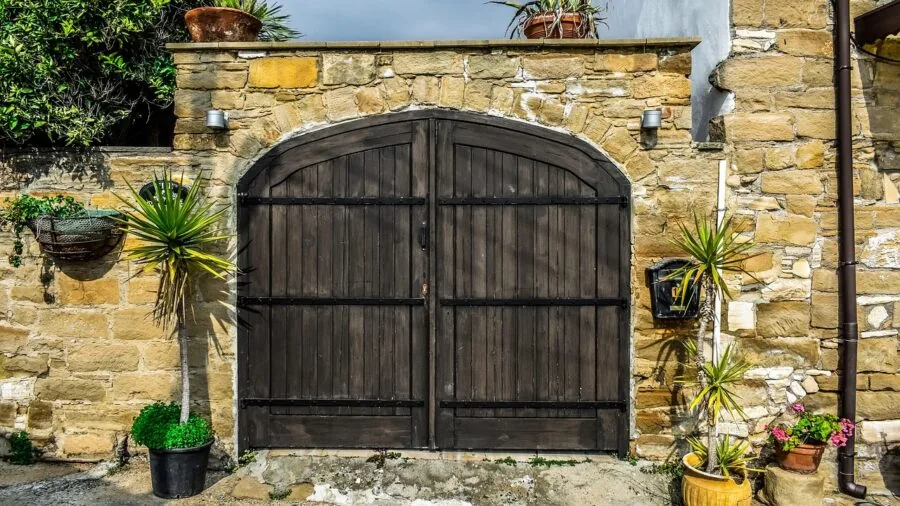 Dog safety gate mounted between white wall and door frame in modern home entryway