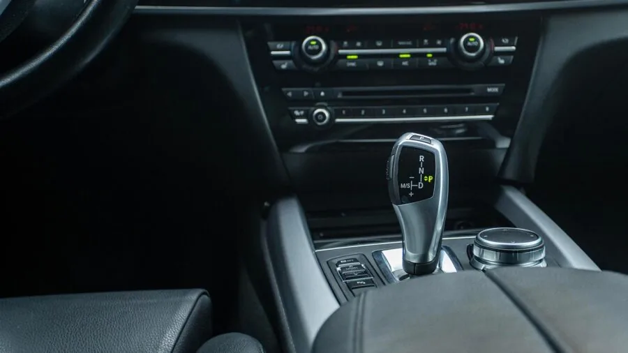 Driver adjusting climate control settings on car seat in vehicle interior