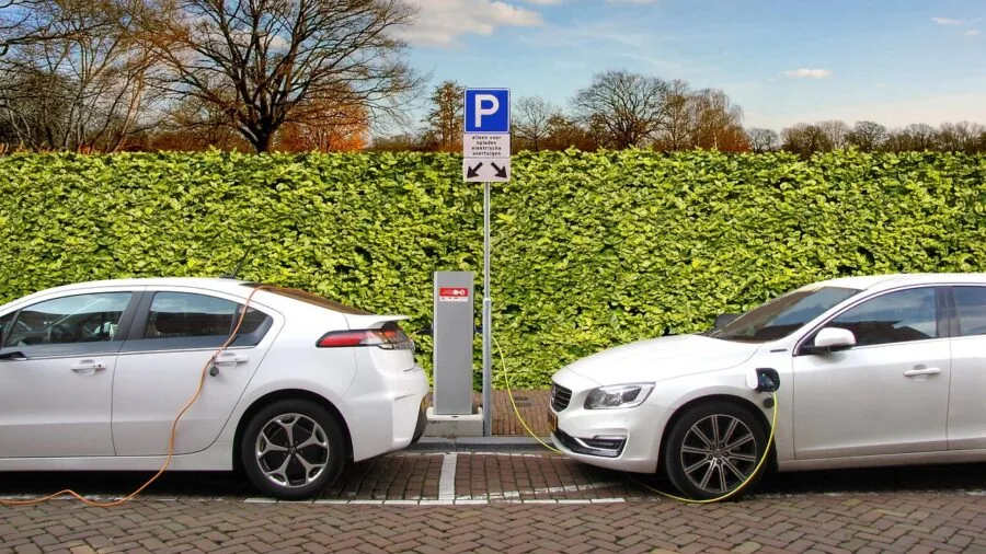 Driver charging smartphone and tablet simultaneously in car dashboard, demonstrating multi-device power management
