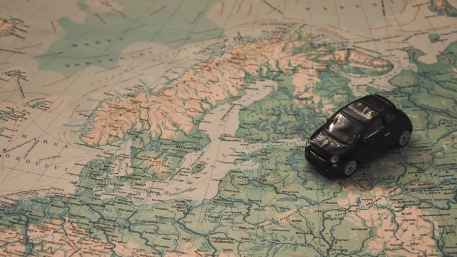 Driver checking GPS navigation on smartphone while planning road trip route in car