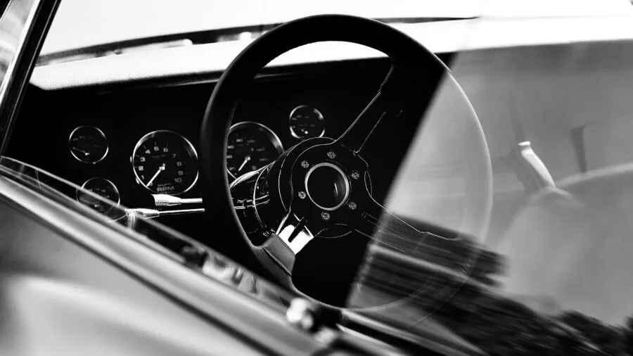 Driver focused on road safety while operating vehicle controls on dashboard