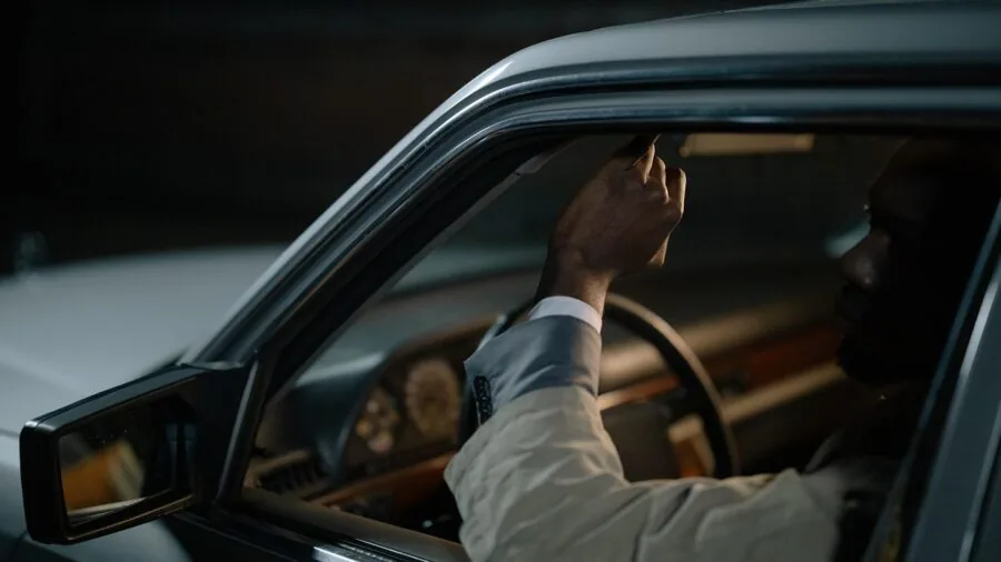 Driver glancing at side mirror while reversing, emphasizing visibility and image clarity while driving