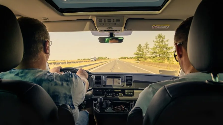 Driver in car adjusting smartphone mount for optimal viewing angle while driving
