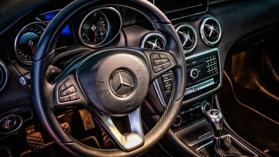 Driver inspecting car interior controls during cold weather to assess heating system functionality