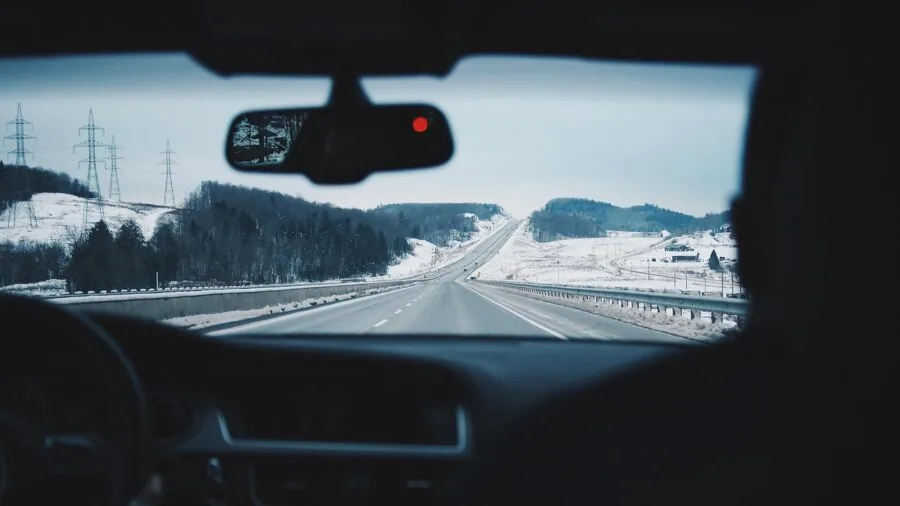 Driver navigating highway with hands on steering wheel during daytime travel