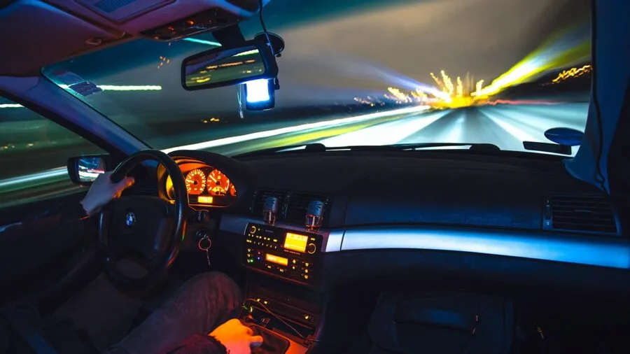 Driver on highway with view of car dashboard and road ahead during daytime travel