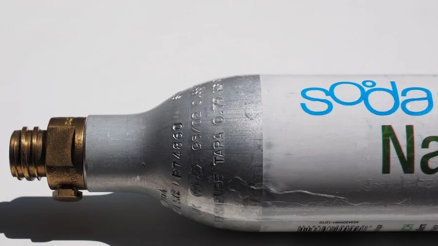 Driver refilling water bottle during road trip break inside vehicle