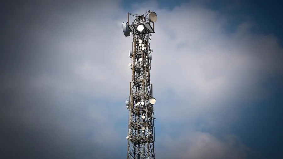 Driver tuning car radio dial while adjusting antenna for better signal reception