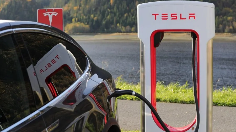 Driver using car charger to power smartphone during road trip, dashboard visible