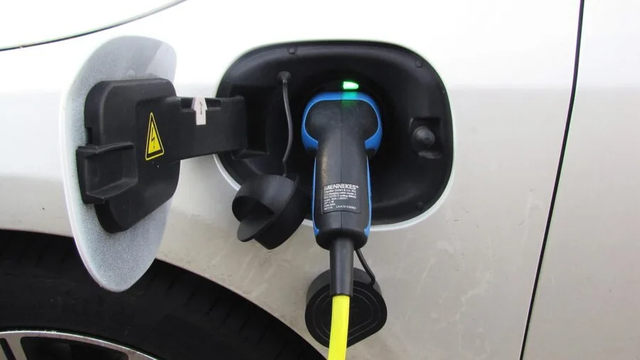 Driver using car charger to power smartphone while sitting in vehicle interior