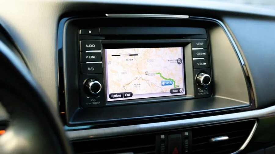 Driver using GPS navigation system while driving on highway for route guidance and safety