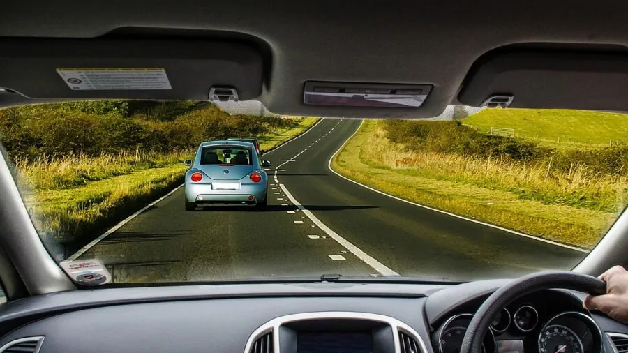 Driver's hand adjusting car dashboard display while driving on road
