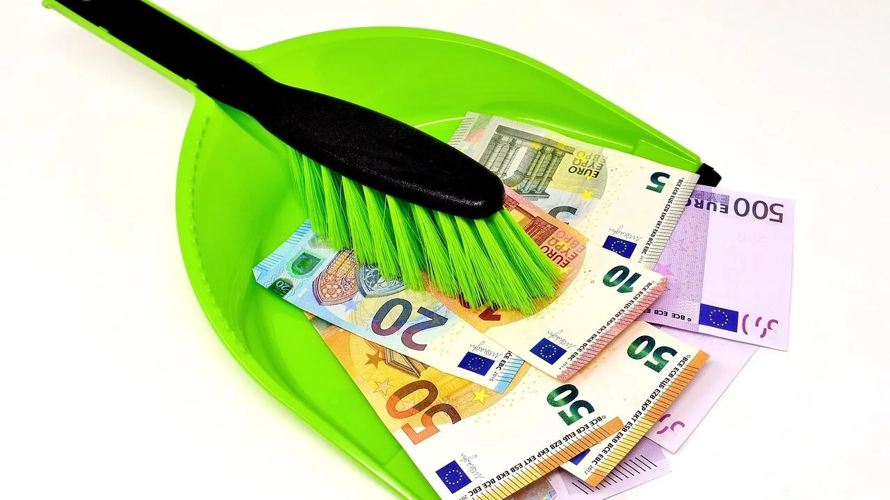 Dustpan and broom set sweeping debris on floor in close-up view