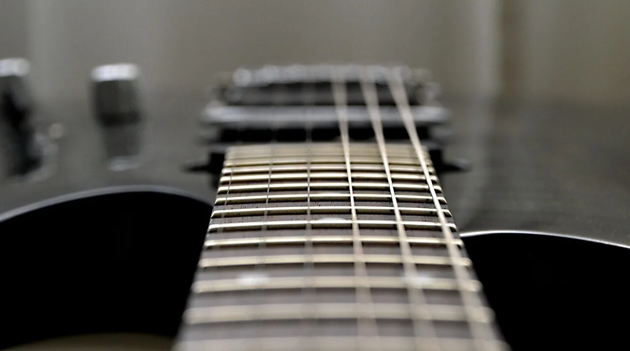 Electric guitar with visible strings and body in sharp focus