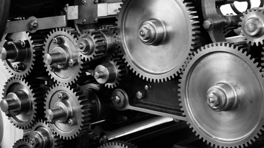 Engineer inspecting detailed mechanical parts and machinery components in workshop setting