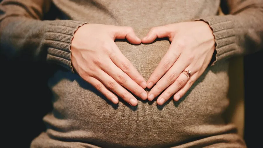 Expectant mother reviewing prenatal supplement information at home