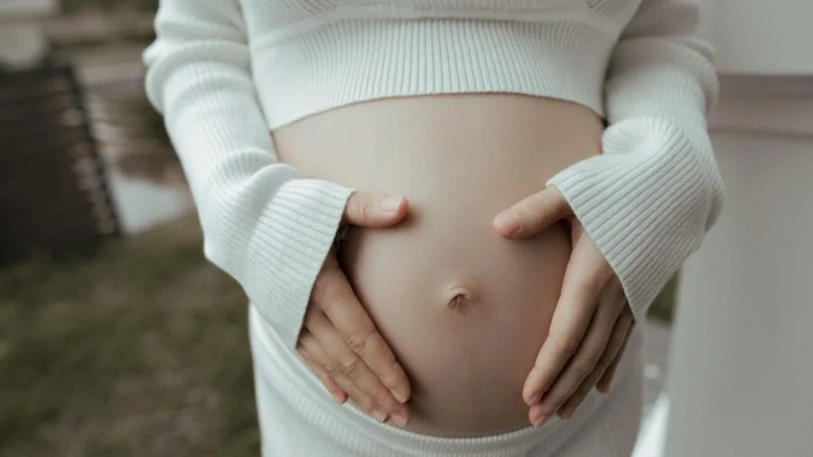 Expectant mother taking prenatal vitamins during pregnancy wellness routine