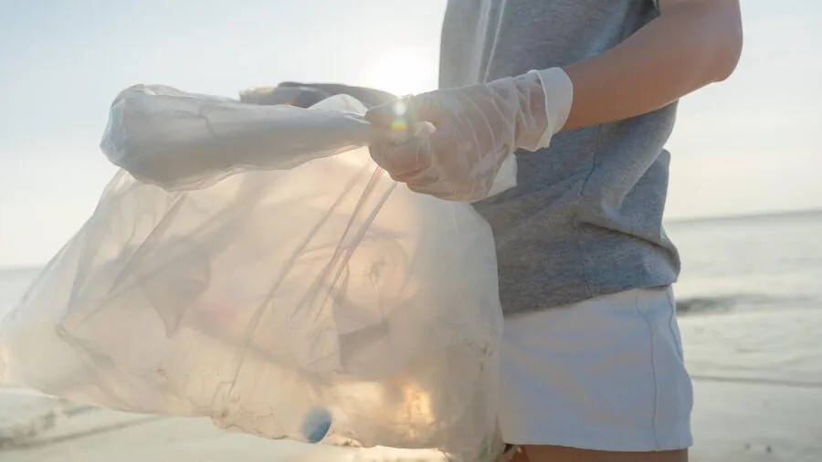 Faded beach bag showing wear from sand and sun exposure on sandy shore