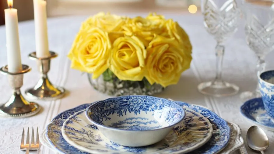 Family gathered around dining table with plated meals and dishware during casual dinner gathering