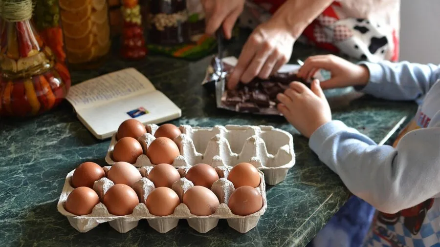 Family gathered around kitchen counter preparing food together during meal preparation