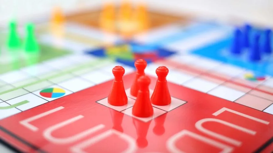 Family gathered around table playing dice game together in casual home setting