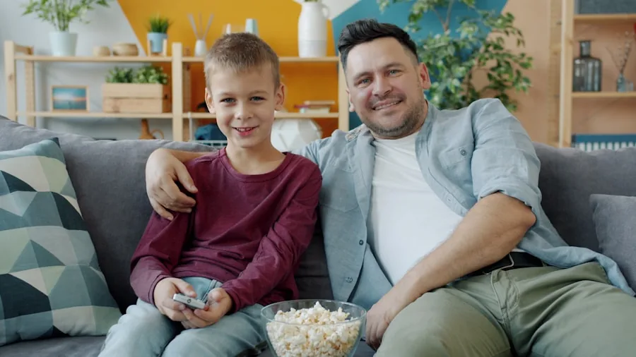 Family gathered in living room watching TV together on a couch during evening