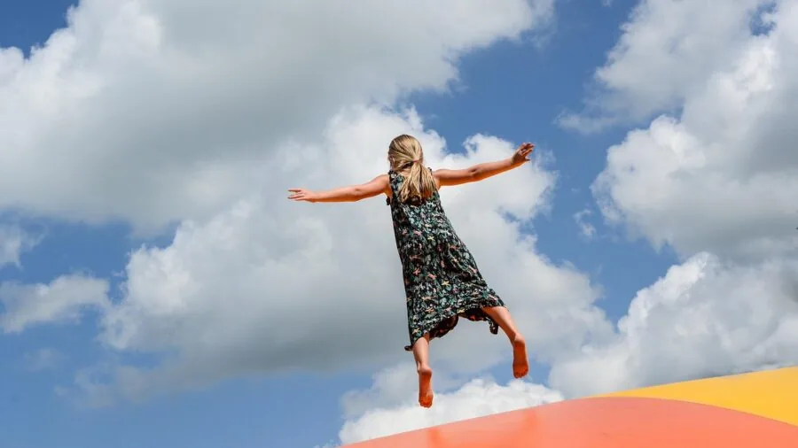 Family members enjoying active play on a backyard trampoline during daytime