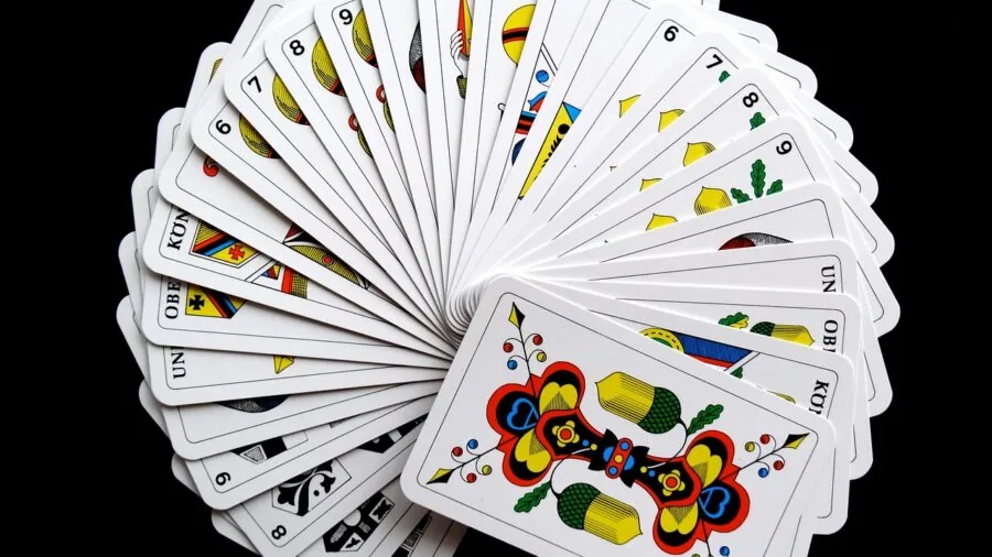 Family members gathered around table playing card games indoors