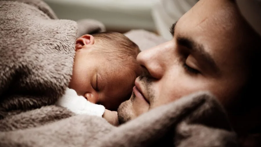 Family members of different ages sleeping peacefully together in comfortable bedding, emphasizing comfort and togetherness